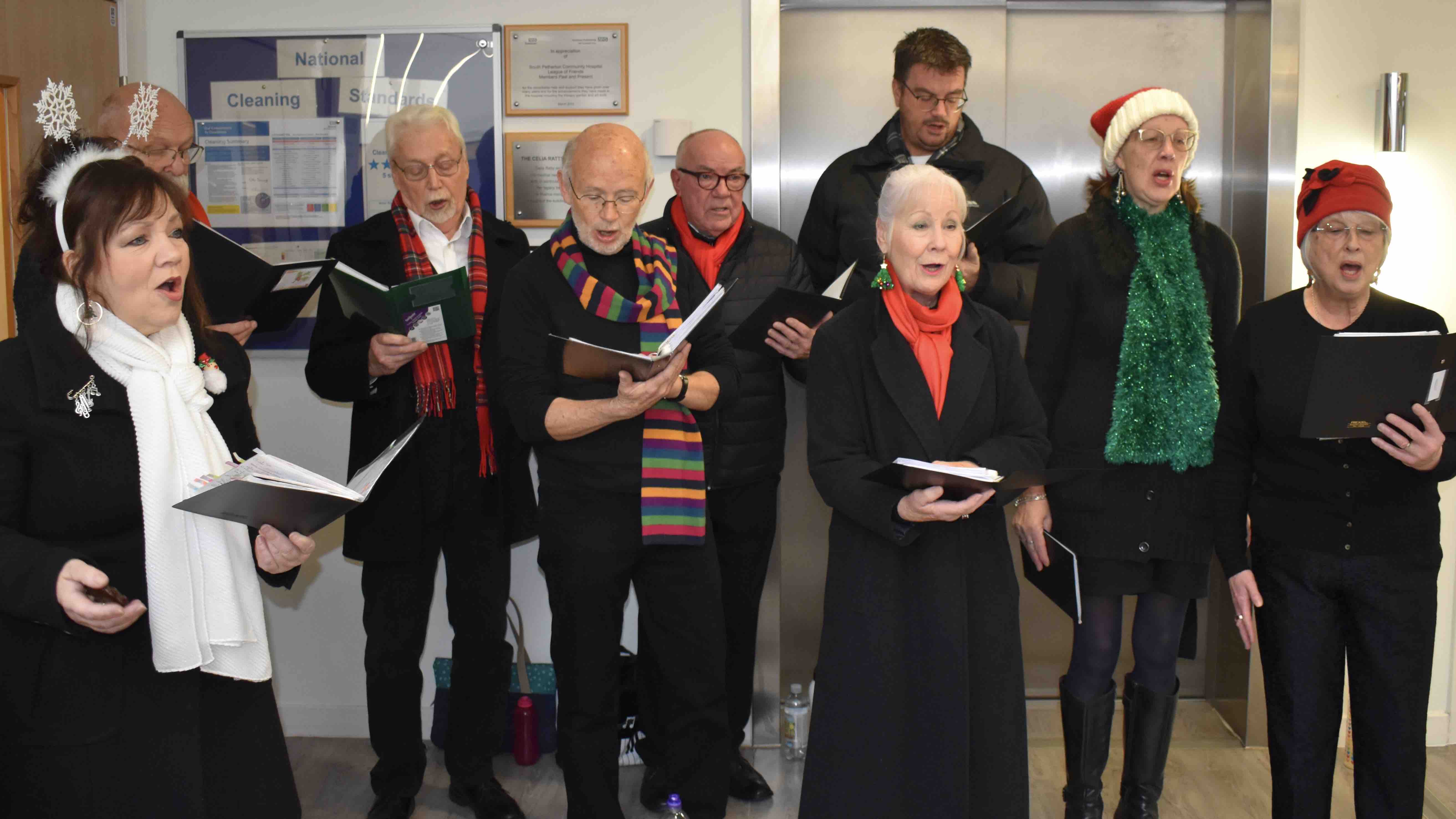 Singers wearing black are performing in the hospital